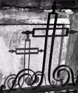 Iron cross casts a shadow on a crumbling crypt in New Orleans St. Louis Cemetery #1